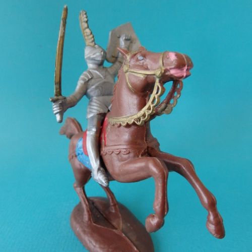 11. Chevalier en armure à cheval, avec épée et bouclier écu levés.