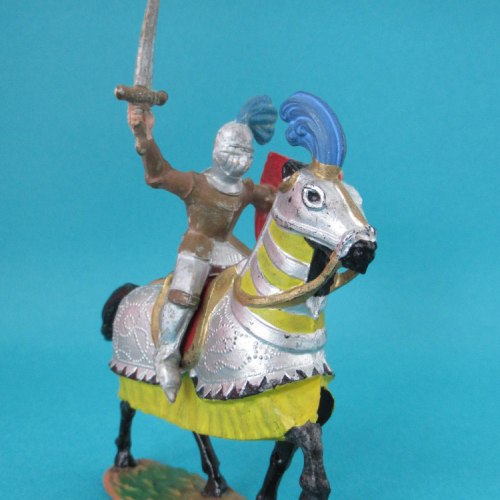 864 Chevalier en armure, casque à plumet, bouclier et épée levés.