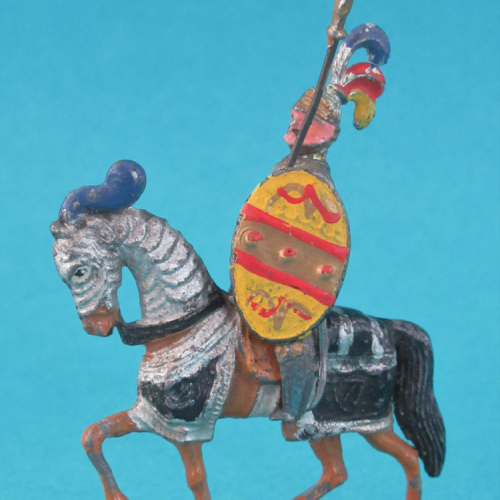 Cheval au trot, cavalier casque à 3 plumet visière ouverte avec lance et bouclier.