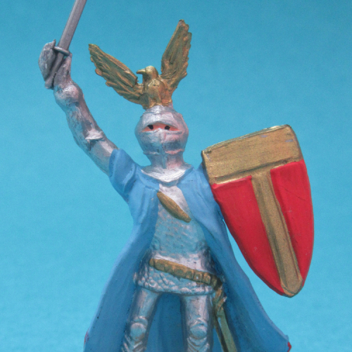1215 Chevalier en armure, jambes parallèles, bras levés avec arme et bouclier, casque aigle et cape.