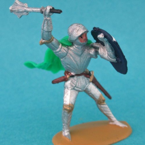 1241  Chevalier en armure se défendant, bras droit levé, bouclier au bras gauche, avec cape.